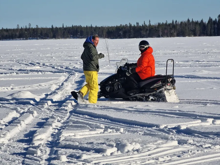 Pausa durante una salida en moto de nieve sobre un lago nevado