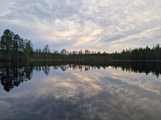 Reflets des nuages et de la forêt dans un lac calme