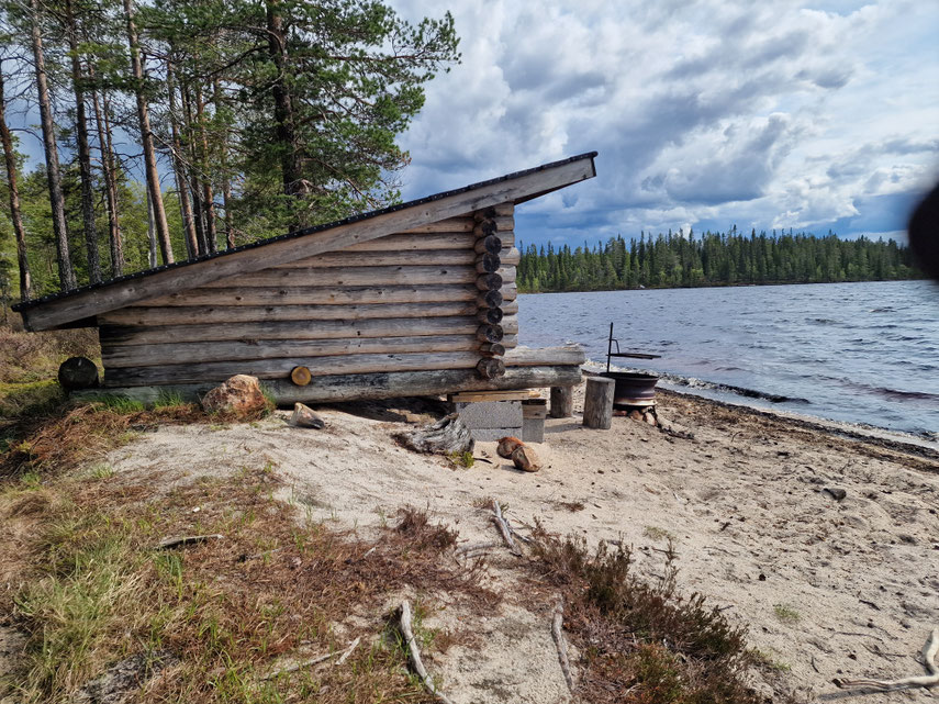Avoin katos istuimineen veden äärellä