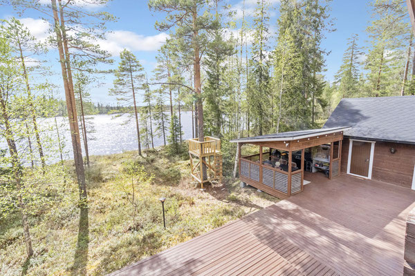 Terrasse et bâtiments en bois parmi les bouleaux au bord du lac