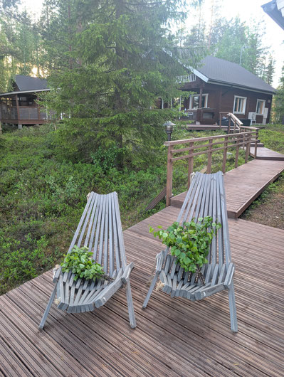 Dos cestas con plantas en la terraza de madera junto a la casa