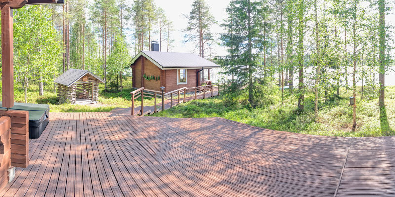 Bâtiment en bois derrière une grande terrasse en forêt