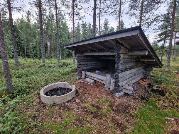 Pieni puukatos ja tulipaikka metsässä