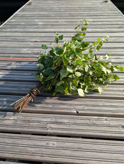 Tied birch branches on a wooden jetty