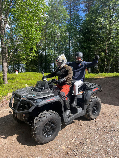 Dos personas sentadas en un quad al aire libre