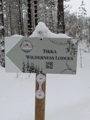 Panneau Tikka Wilderness Lodges enneigé dans la forêt