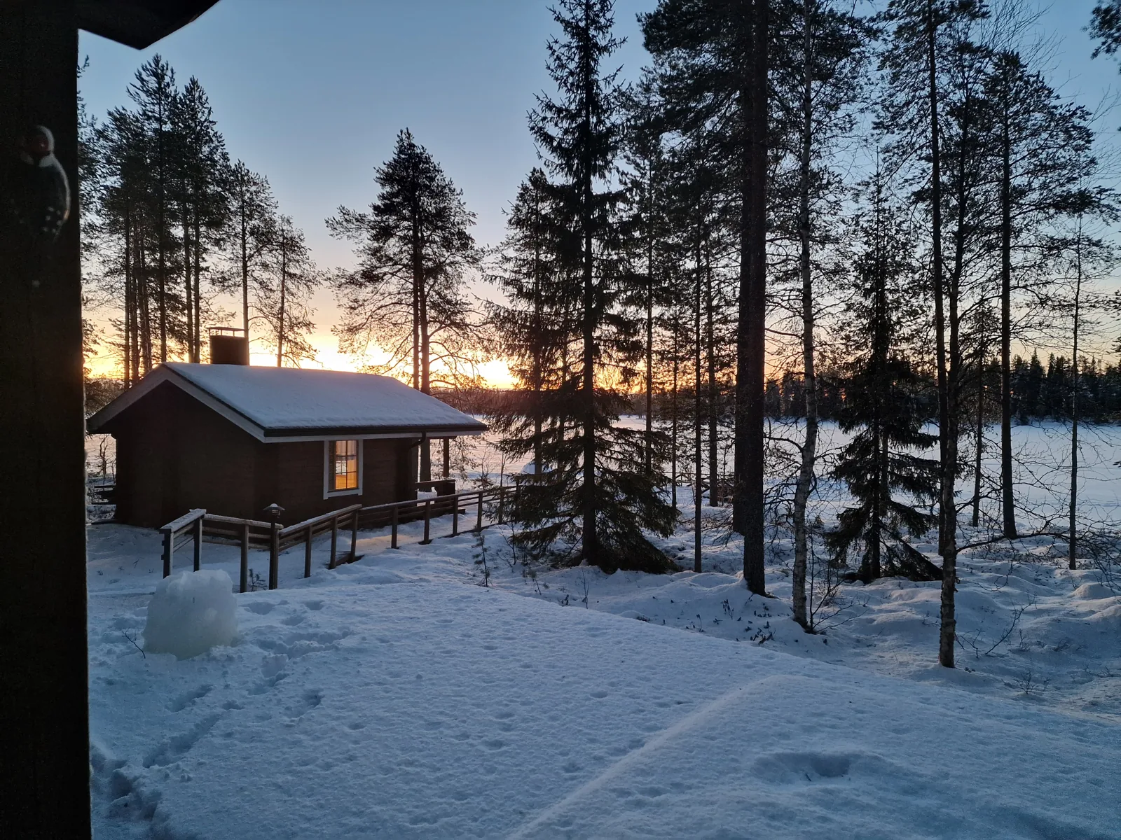 Verschneite Strandsauna am See im Winterlicht