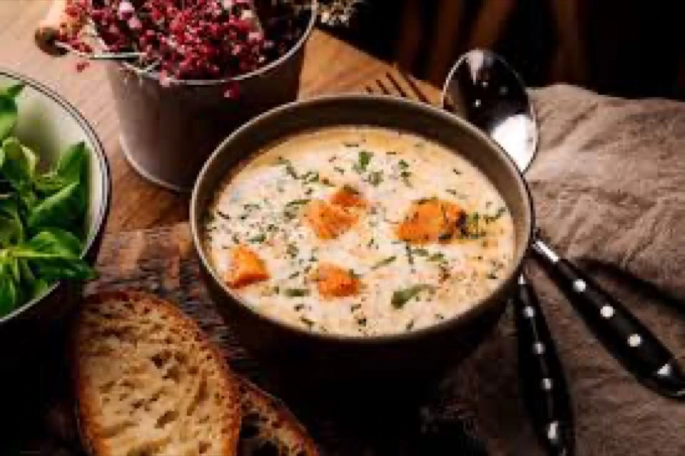 Suppe mit Brot auf einem gedeckten Tisch
