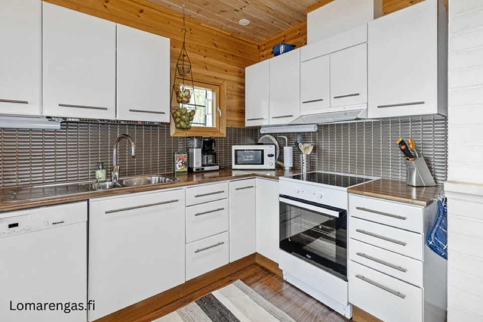 Küche im Haupthaus mit Herd, Backofen und weissen Schränken
