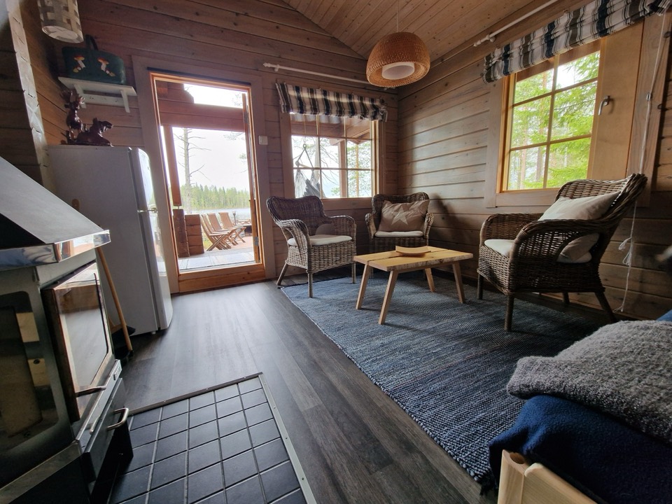 Kaminzimmer im Saunahaus mit Sofa, Sesseln und Blick zum See