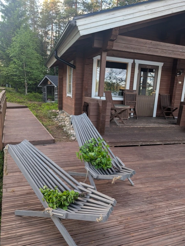 Liegestühle mit Birkenzweigen vor dem Saunahaus