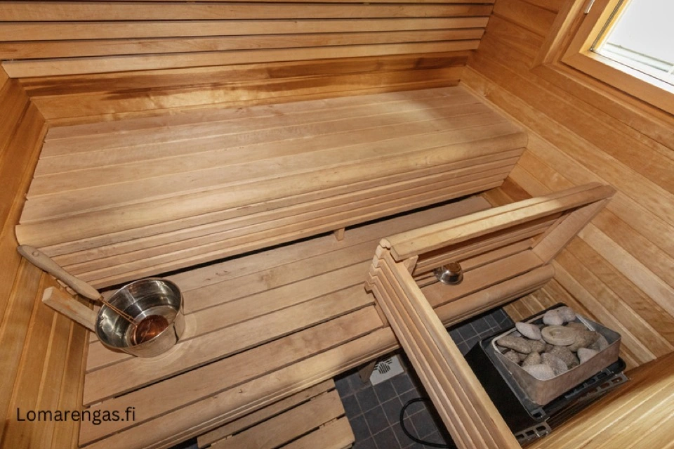 Sauna im Haupthaus mit Holzbänken und Saunaofen