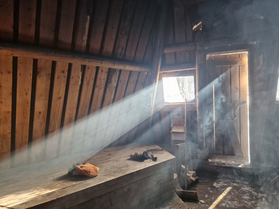 Sonnenlicht fällt durch das Fenster einer Kota auf die Holzbänke