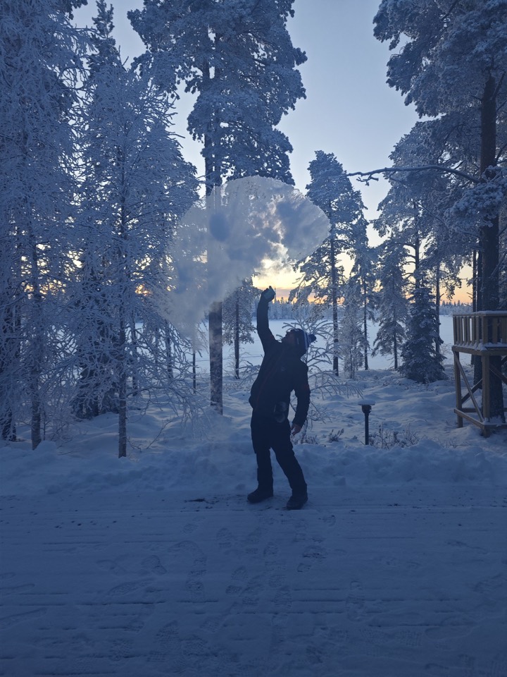 Person zwischen schneebedeckten Bäumen im Winterwald